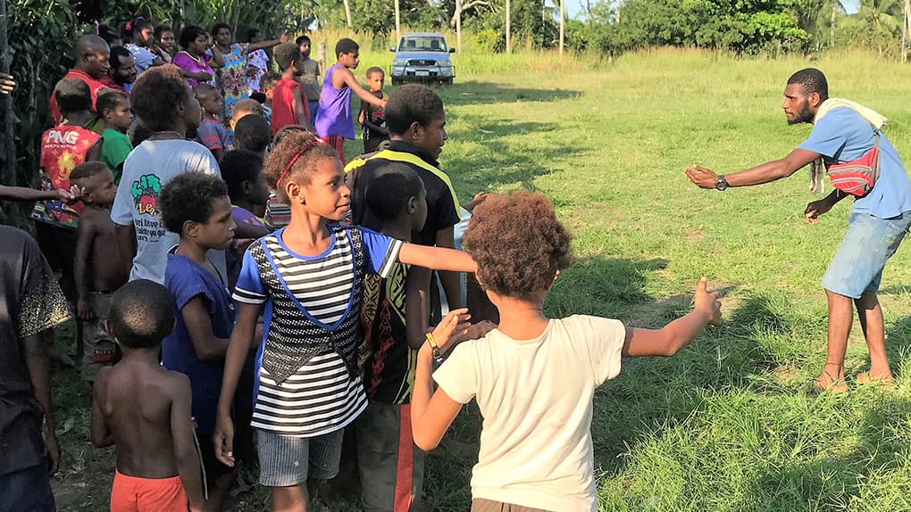 In Papua-Neuguinea spielen Eltern und ältere Geschwister nicht mit den Kleinen. Dafür sind sie in ihren Augen nicht wertvoll genug. Die Kinder verbringen daher ihren Tag irgendwo auf der Straße und kommen erst abends wieder heim. Deshalb engagieren wir uns gemeinsam mit ehrenamtlichen Mitarbeitern wie Justin (rechts im Bild) in einem Kidsclub.