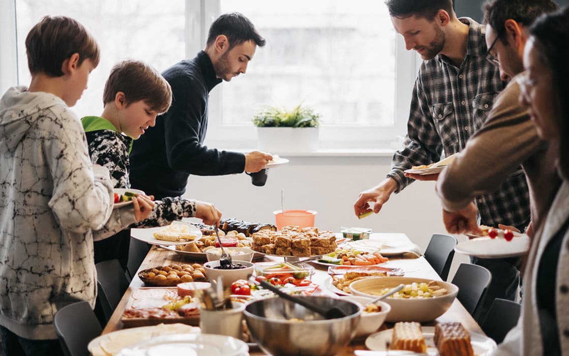Eine Gruppe genießt ein zwangloses Treffen in der Stuttgarter Lifepoint-Kirche und bedient sich an verschiedenen Gerichten.