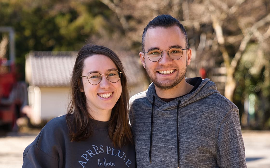 Stefan Degler und Lara Degler, beide Brillenträger, lächeln an einem sonnigen Tag im Freien zusammen.