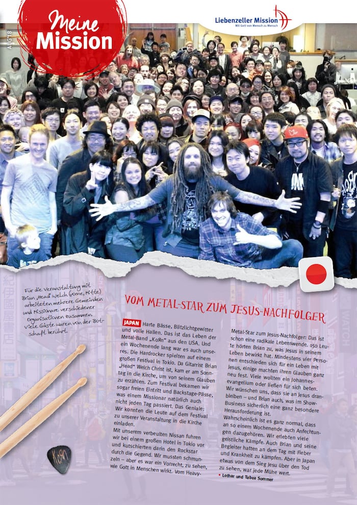 Ein bärtiger Mann mit langen Haaren steht mit ausgestreckten Armen vor einer lächelnden Gruppe - Meine Mission, August 2018.