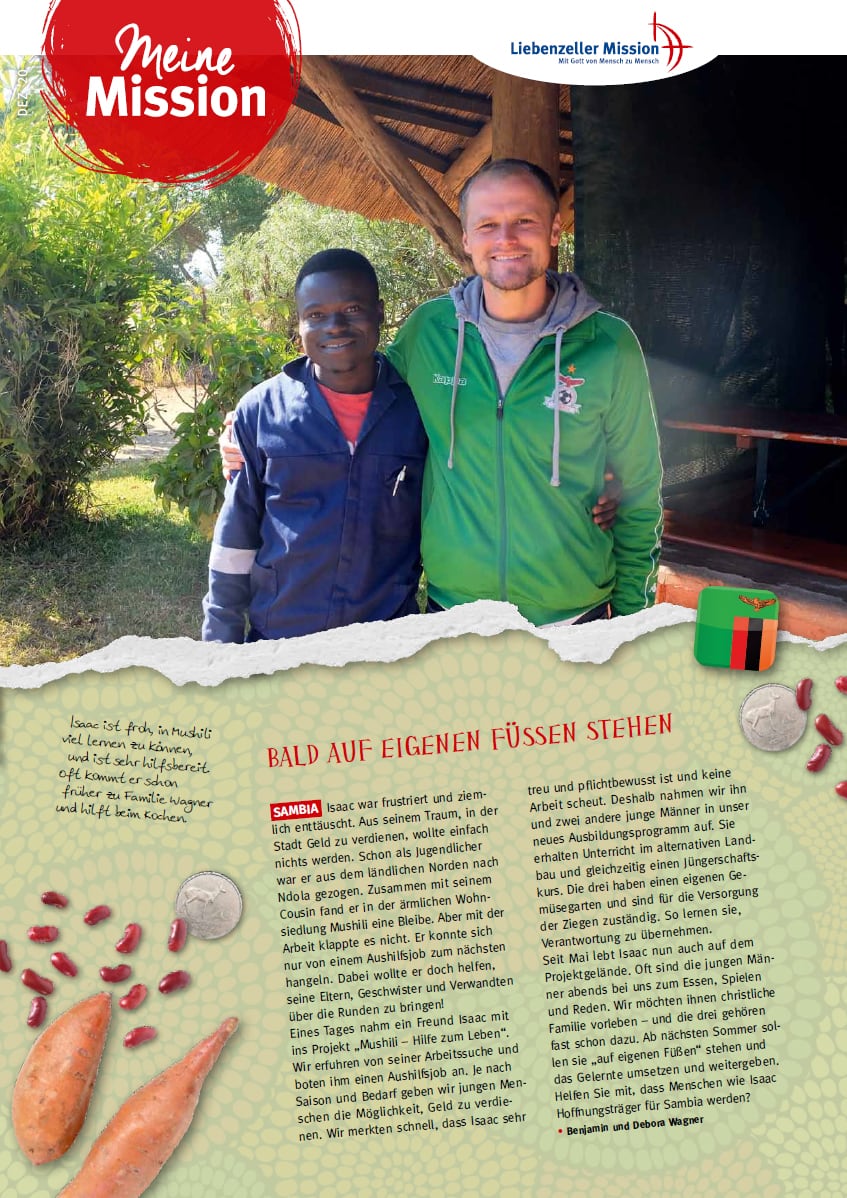 Zwei Männer in blauen und grünen Jacken lächeln während der Mission Dezember 2020 im Freien nebeneinander, die Bäume im Rücken.