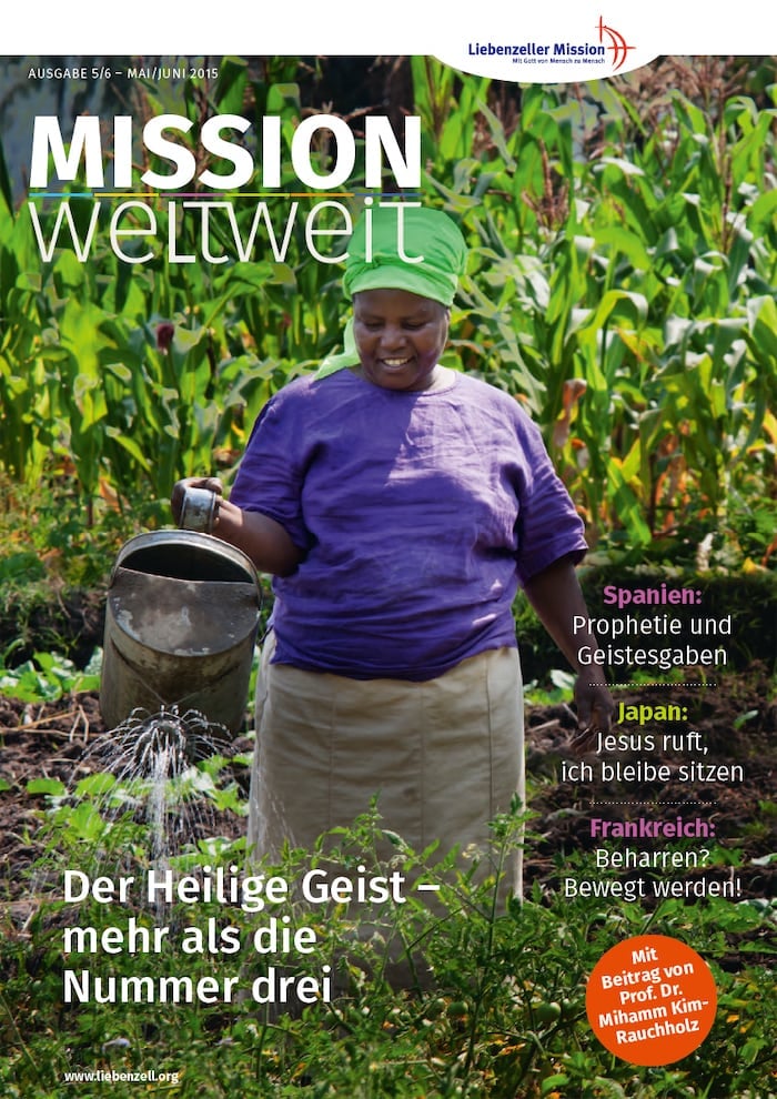 Lächelnde Frau in lila Kleidung bewässert einen grünen Garten mit einer Metallgießkanne unter hellem Sonnenlicht.