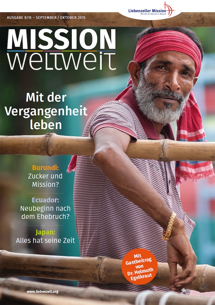 Ein Mann mit einem roten Stirnband lehnt an einem Bambuszaun; über dem Bild erscheint ein Text in deutscher Sprache.