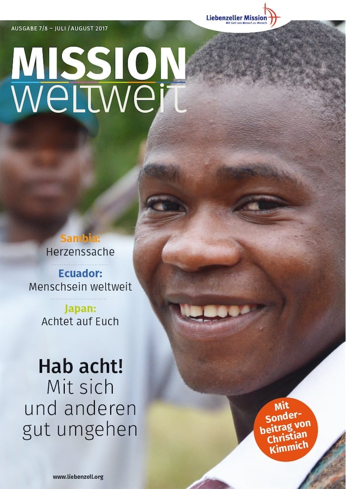 Lächelnder junger Mann im Vordergrund; ein weiterer Mann im unscharfen Hintergrund; Titelseite eines deutschen Missionsmagazins.