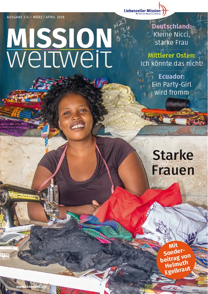 Lächelnde Frau an einer Nähmaschine mit bunten Stoffen, abgebildet auf dem Titelbild einer Zeitschrift mit dem Titel Mission Weltweit.