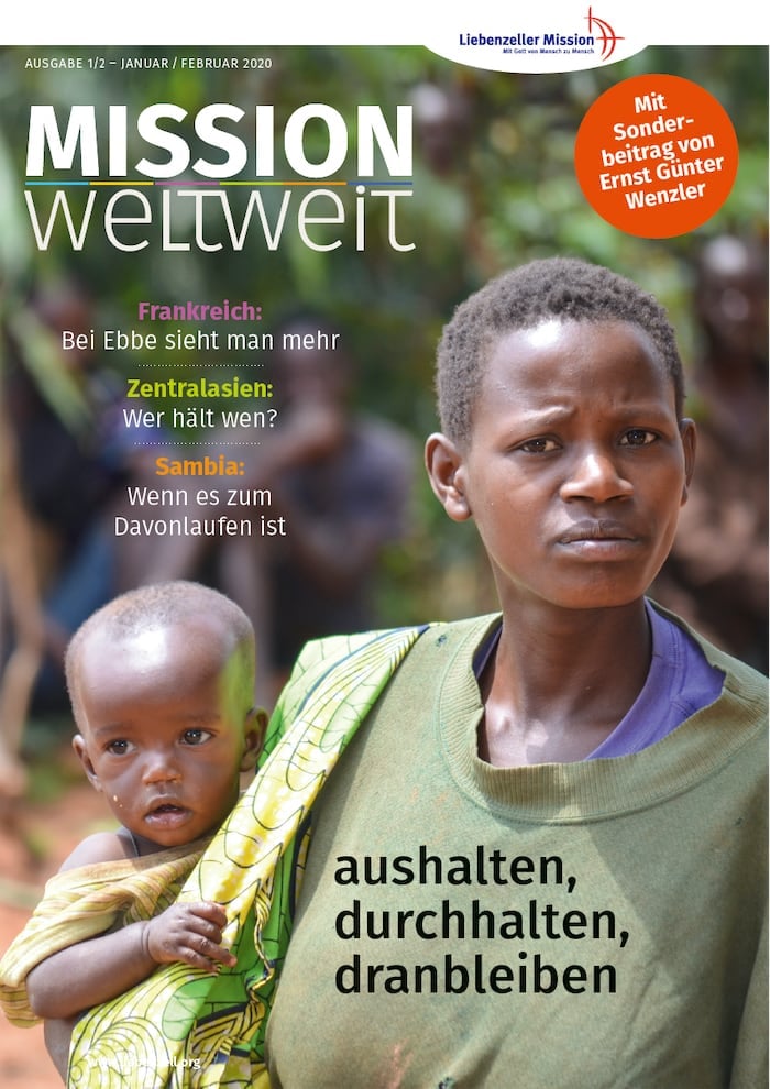 Eine Frau hält im Freien ein kleines Kind, beide blicken ernst in die Kamera; der Text einer Zeitschrift überlagert das Bild.