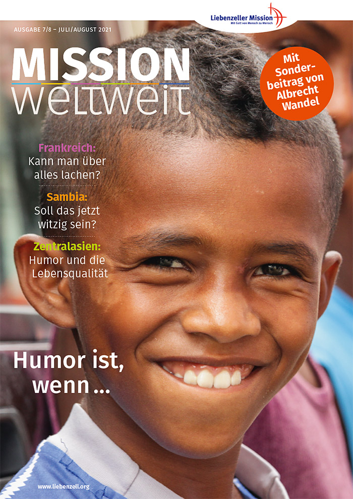 Ein lächelnder Junge mit kurzen Haaren steht im Freien, hinter ihm ist ein anderes Kind zu sehen, das auf dem Titelbild einer deutschen Zeitschrift abgebildet ist.