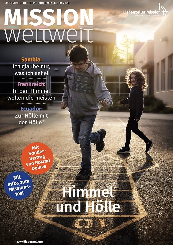 Zwei Kinder spielen bei Sonnenuntergang auf einem Spielplatz Himmel und Hölle; ein Mädchen lächelt, während ein Junge hüpft.