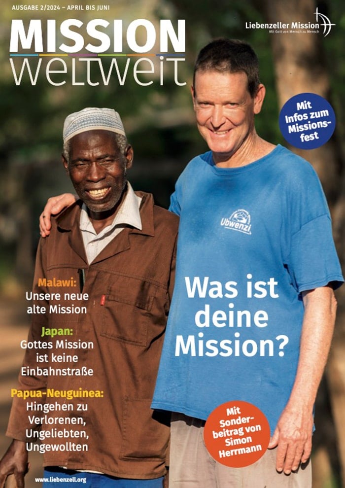 Zwei lächelnde Männer stehen Arm in Arm im Freien und sind auf dem Titelblatt einer deutschen Zeitschrift für christliche Mission abgebildet.