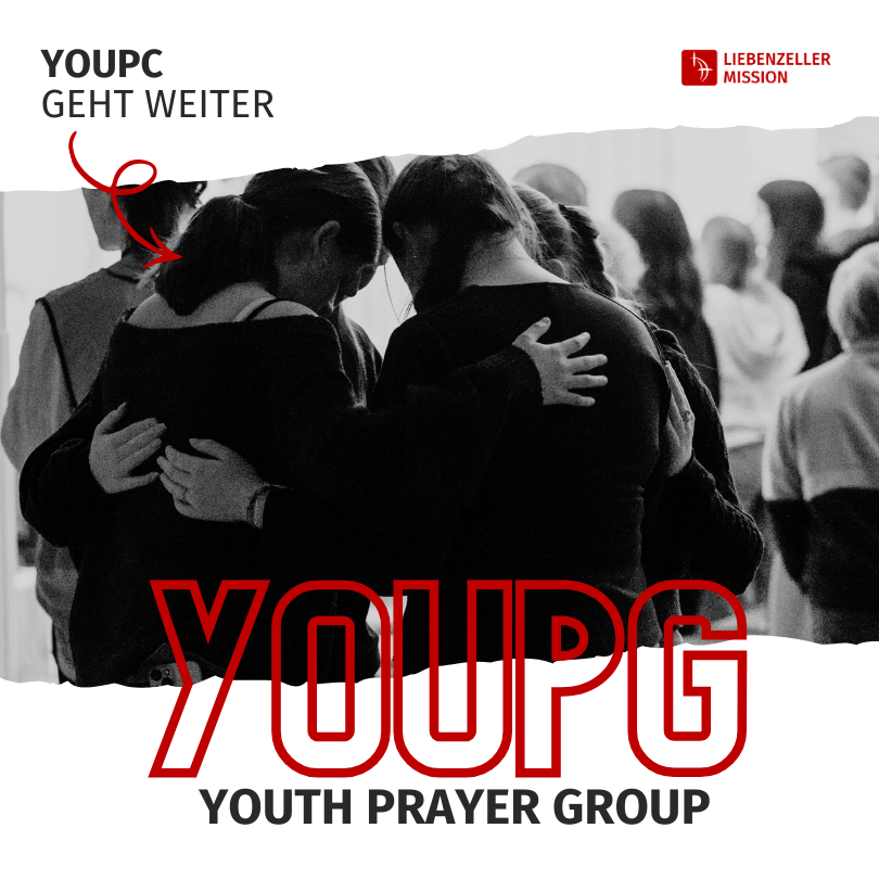 Eine Gruppe junger Menschen steht dicht beieinander, betet mit gesenktem Kopf und legt die Arme umeinander.