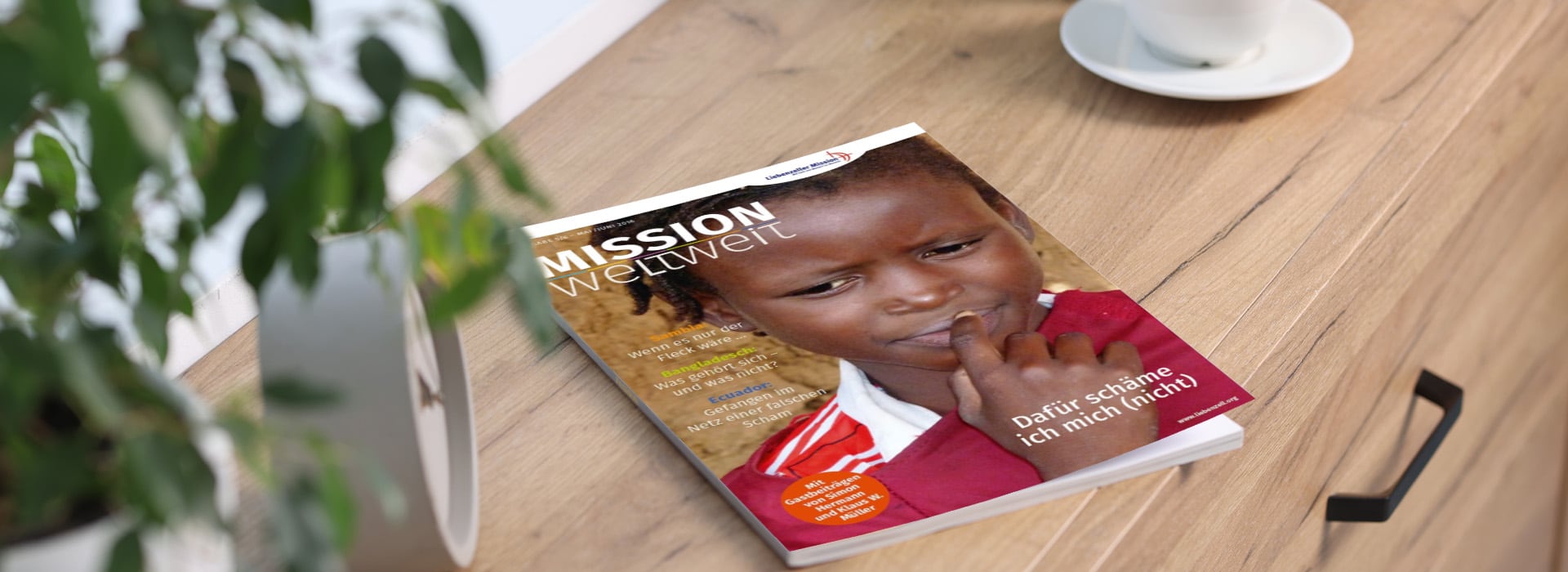 Die Zeitschrift „MISSION weltweit“ mit einem nachdenklichen Kind auf dem Titelblatt, das auf einem Holztisch neben einer weißen Tasse sitzt.