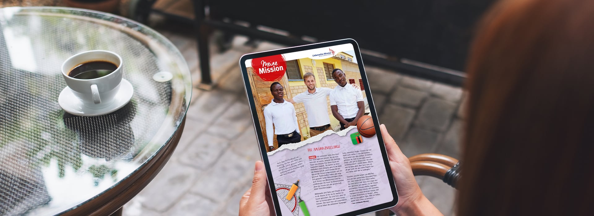 Eine Person, die ein Tablet in der Hand hält, auf dem ein digitales Magazin mit einem Foto von drei Personen und einem Artikel zu sehen ist, daneben steht eine Tasse Kaffee.