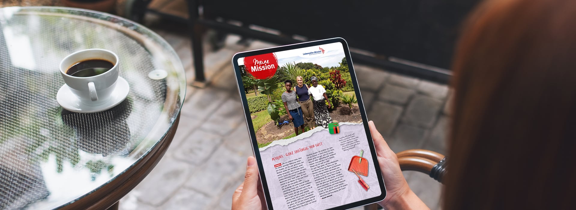 Eine Person, die ein Tablet mit einem geöffneten digitalen Magazin in der Hand hält und draußen an einem Tisch mit einer Tasse Kaffee sitzt.