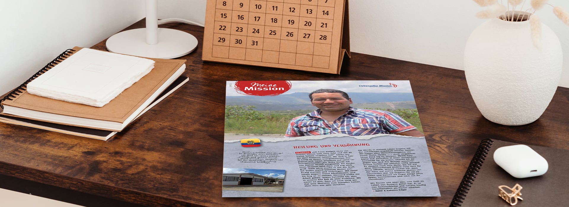 Ein Flyer mit dem Foto eines Mannes auf einem Schreibtisch, neben Notizbüchern, einem Kalender, einer weißen Lampe und einer Computermaus.